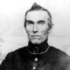 Older white man holding a revolver in military uniform