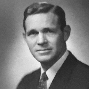 White man with side-parted hair in suit and tie