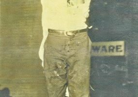 Young African-American man tied to a pole bleeding