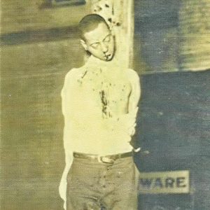 Young African-American man tied to a pole bleeding