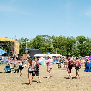 Crowd of white visitors gathered in front of outdoor stage during the day