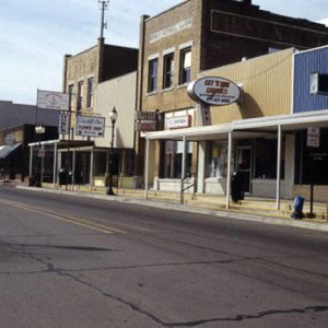 Storefronts on street with signs and street lamps