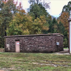 Single-story brick building next to metal building with garage bay door