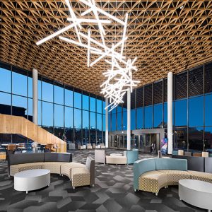 Interior of Walton Arts Center with modern furniture glass walls chandelier and stairs