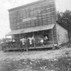 Men standing on porch of wooden building