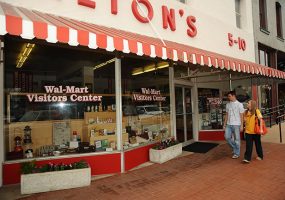 "Walton's" store with red and white awning and "Wal-Mart visitors center" on the windows