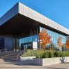 Multistory modern building with covered porch hanging glass windows and flat roof