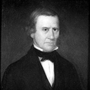 Older white man in suit with white shirt and black bow tie