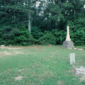 Gravestones and obelisk monument on three-tiered pedestal in cemetery