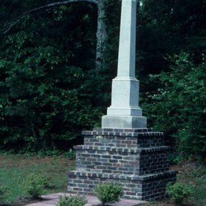 Obelisk shaped monument on three-tiered brick pedestal