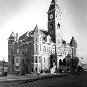 Three-story courthouse with bell and clock tower and arched entrances