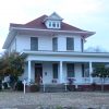 Multistory house with covered porch on grass