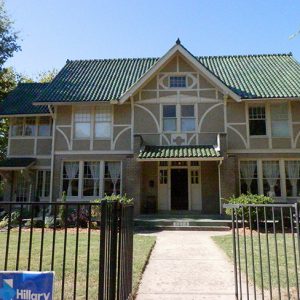 Multistory house with covered entrance inside iron fence