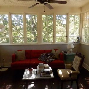 Interior of room with couch table and chair with windows overlooking trees