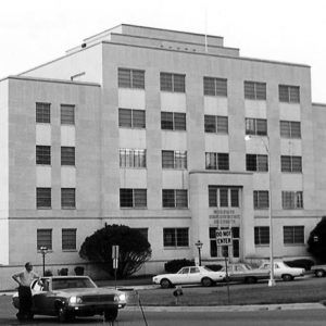 Blocky six-story building with parking lot