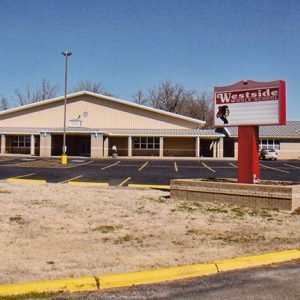 Single-story buildings on parking lot with "Westside" sign