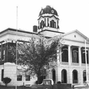 Brick building with four columned entrance and clock tower