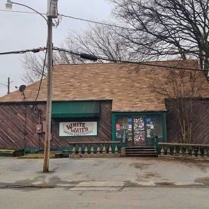 Single-story building with wood siding and parking lot