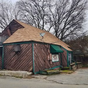 Side view of single-story building with gabled roof and parking lot