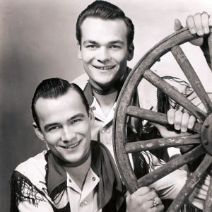 Young white men in western suits with wagon wheel