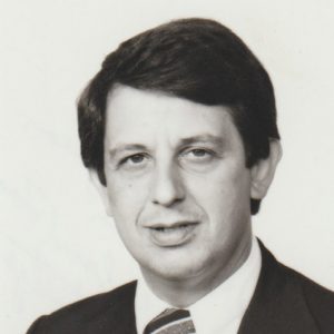 White man smiling in suit and tie