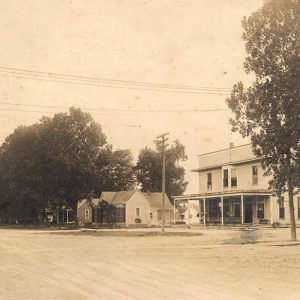 Multistory building with covered porch and houses on town street