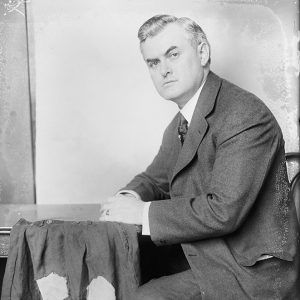 White man in suit sitting in chair