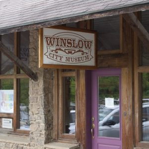 Brick and stone building with "Winslow City Museum" sign over a purple door