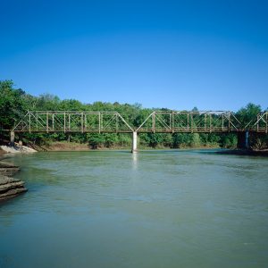 Bridge across a river with trees along the shoreline