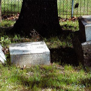 Broken "Gilbert" gravestone in cemetery