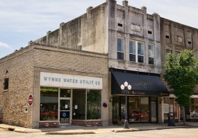 Single-story "Wynne Water Utilities" building and two-story store fronts on street