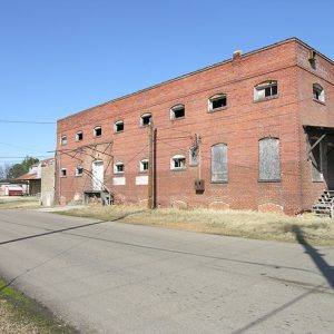 narrow two-story brick building on street with wooden steps