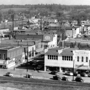 elevated view downtown with railroad in foreground cars pedestrians businesses and neighborhoods in background