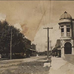 Looking down street with power lines and multistory buildings on both sides