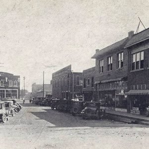 Cars parked outside multistory brick buildings on street