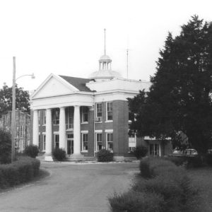 Two-story brick building with four columns and dome roof