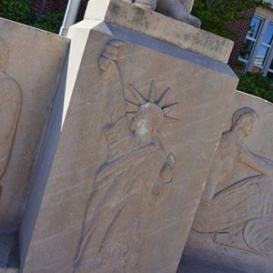 Statue on pedestal with statue of liberty relief below it