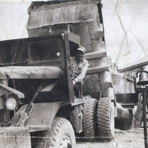 White man in dump truck with the bed raised