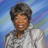 African-American woman with short hair smiling in silver dress