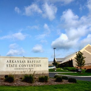 Side entrance to building with sign reading "Arkansas Baptist State Convention" and parking lot