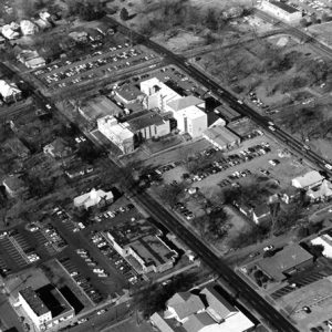 Birds eye view of six building campus and surrounding neighborhood street grid cars and trees