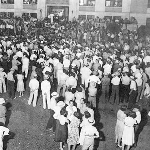 Crowd of people gathered outside multistory building