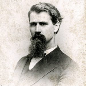 White man with long beard in suit and tie