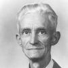 Old white man with gray hair in suit and tie