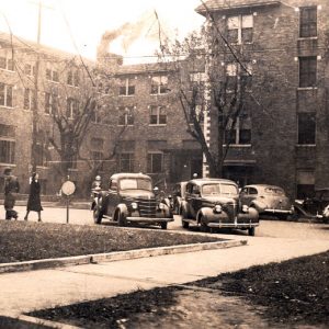 Four-story building with decorative brick corners and parked cars