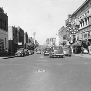 City street with traffic and "Purvis Jewelers" on the right