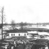 Houses in flooded fields with trees and debris