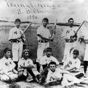 Baseball team photo with white men in "WR" jerseys holding bats, hand-signed "Walnut Ridge B.B Club. 1894."