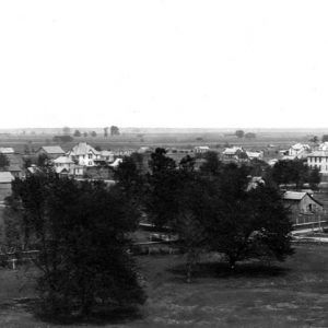 Town view from above with roads, houses, barns, trees, horizon in distance