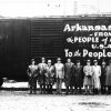 Group photo white men in suits, hats, stand by railcar marked "Union Pacific" with painted sign "Arkansas Rice from the people of Arkansas U.S.A. to the people of Europe."